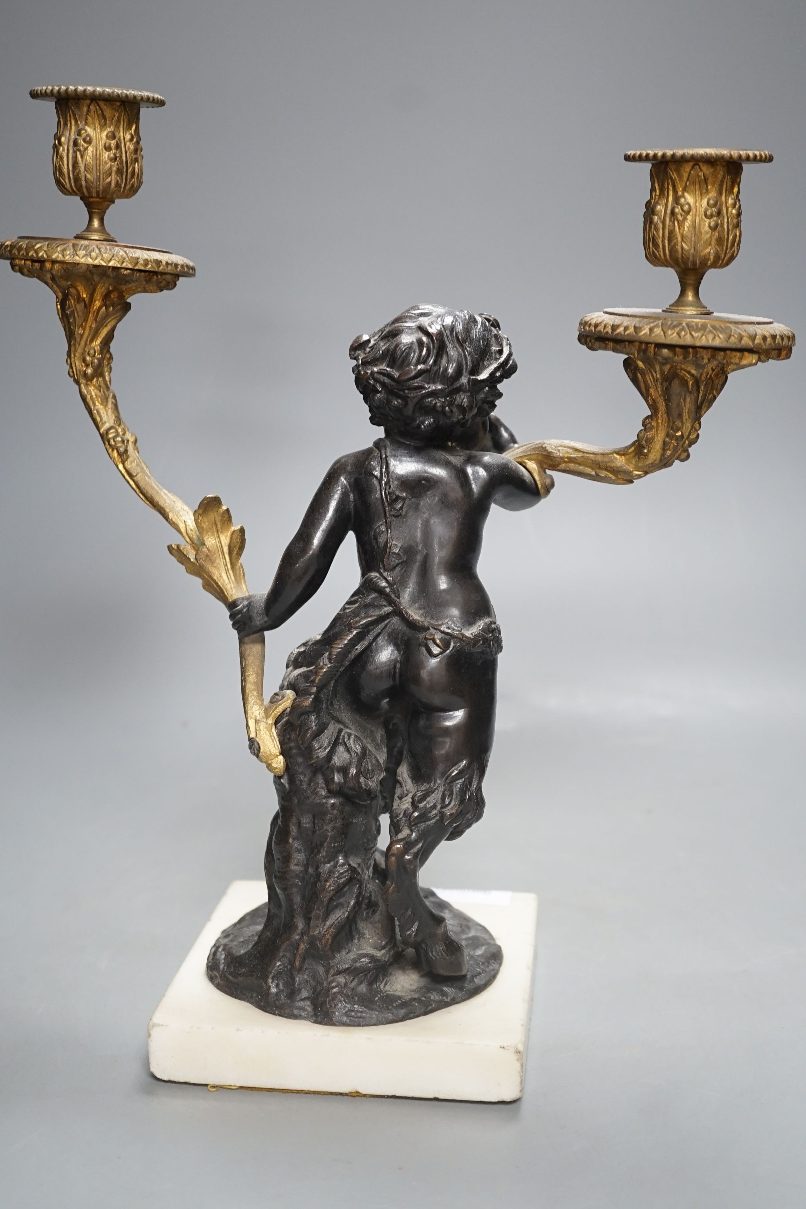 A bronze and ormolu putto two branch candelabrum-33 cms high.